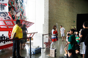 Students learn all about the Hirosaki Neputa dashi (festival car) as they stand right in front of it.