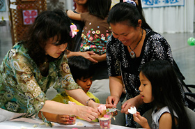 Mom and kids challenge themselves to ikebana (flower arrangement).