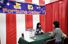 Uranai Corner, fortune telling, first time at the Honolulu Festival. The person having her palm read is quite serious!