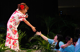 Yamada Kuniko shakes hands with a member of the audience as she sings her song.