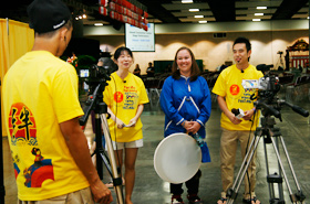 The students interview a member of the Alaska Native Heritage Center Dance Group after they finish their performance.