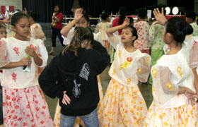 The students learn a Filipino dance from the performers. They are all children, quick friendships made! 