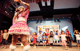 The children of Hawaii perform with Momoi on stage.